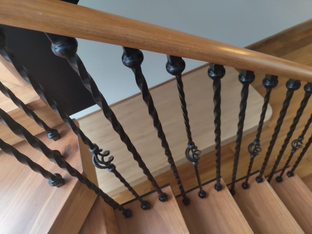 The Best Railing Design for Your Home: A Specialist’s Guide to Modern, Homey & Classic Styles 3 Elegant wrought iron railing with intricate scrollwork on a classical staircase, bringing timeless sophistication