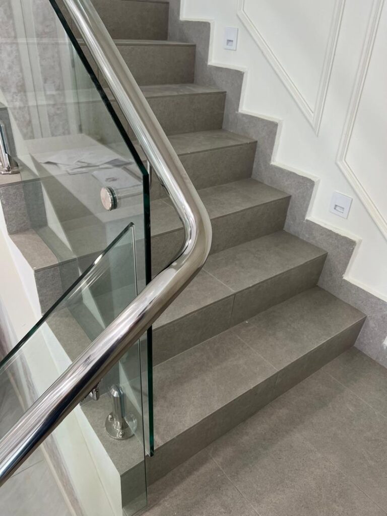 The Best Railing Design for Your Home: A Specialist’s Guide to Modern, Homey & Classic Styles 1 Modern staircase with frameless glass railing and stainless steel handrail in a bright Malaysian living room